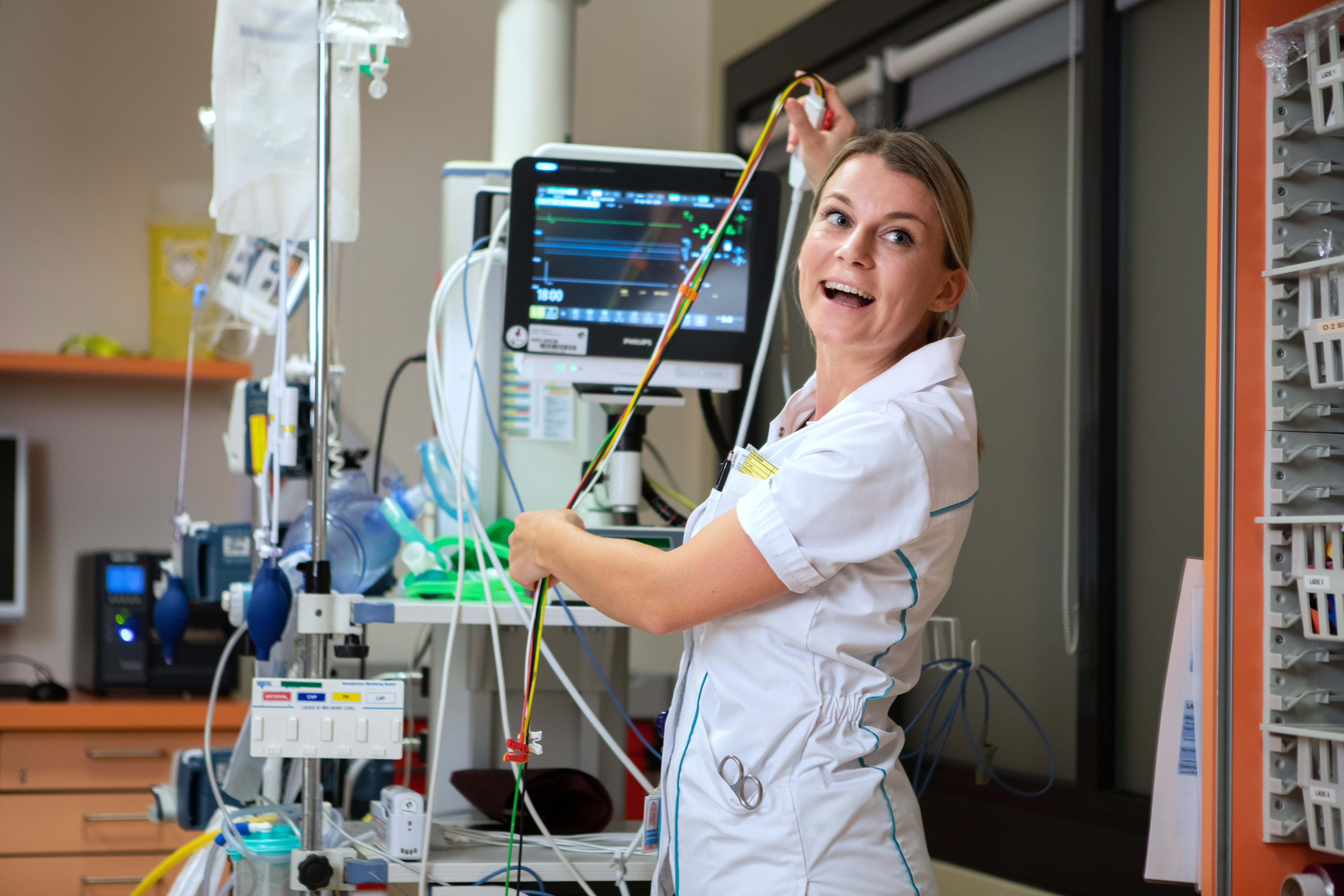 Verpleegkundige sorteert snoeren van Spoedeisende Hulp monitor. 